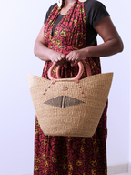 Brown leather handle detail on handwoven elephant grass market basket Ghana
