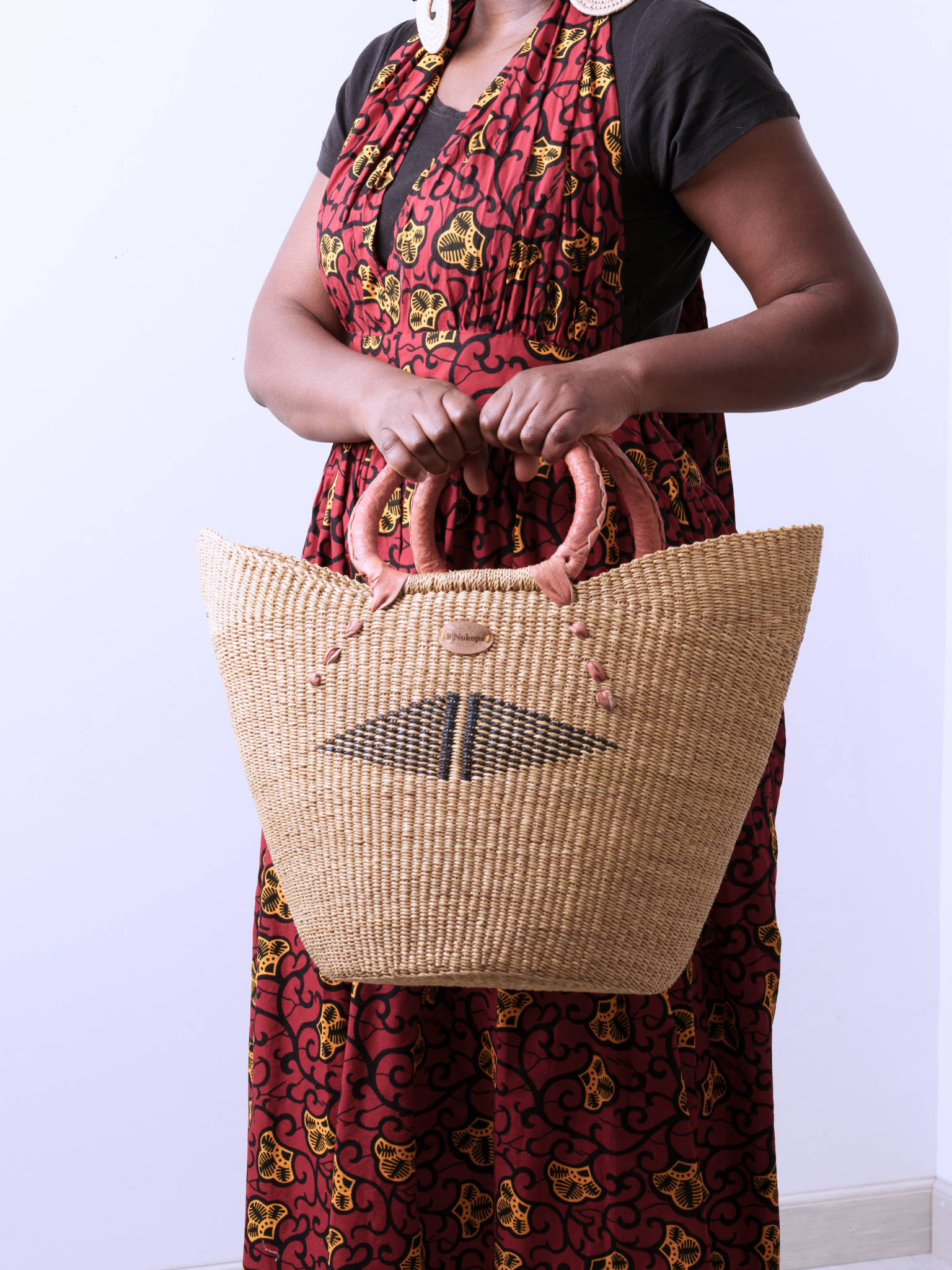 Brown leather handle detail on handwoven elephant grass market basket Ghana